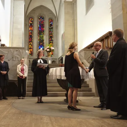 Ordination in der Kirche, Pfarrerin steht in der Mitte