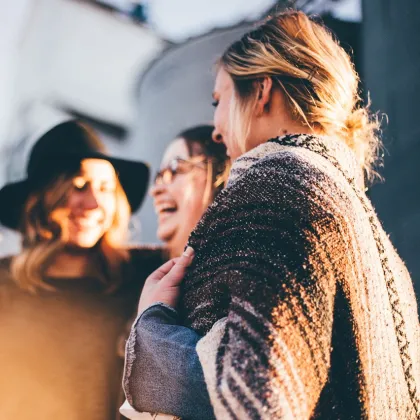 Junge Frauen stehen zusammen, reden und lachen